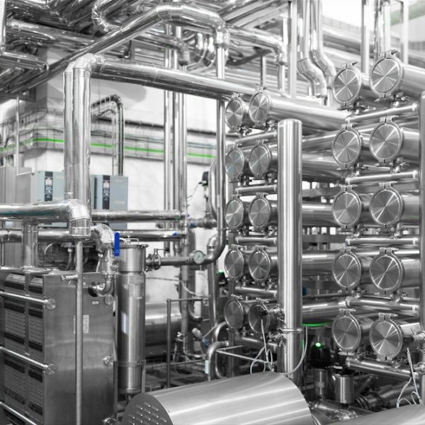 chrome-plated Industrial background. Equipment, industrial tools and machinery for the production in factory shops. dairy factory. Steel water pipeline, chrome pipes. Modern factory interior. Production line. Maze of metal pipes background